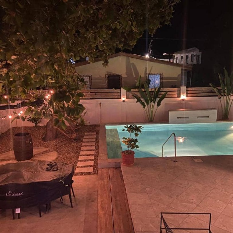 Illuminated backyard pool and patio area at night